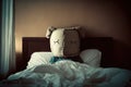 Sad boy with a big pillow on his head lying in bed Royalty Free Stock Photo