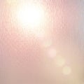 Softly textured surface with a pinkish hue, illuminated by a bright light in the upper left Royalty Free Stock Photo