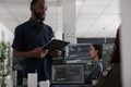 Software developer holding clipboard checking html code on terminal window