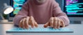 Software developer typing on illuminated keyboard with code on screen in modern workspace Royalty Free Stock Photo