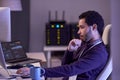 Software developer working at night writing code at desk