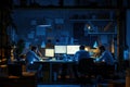 Software developers coding on computers in dark office at night Royalty Free Stock Photo