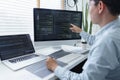 Software development concept, Male programmer checking data codes on document and computer screen