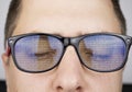The programmer`s glasses reflect lines of code. Programming, development of applications, sites and other things. Software