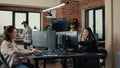 Software engineer typing source code on computer keyboard while colleagues sit down at desk Royalty Free Stock Photo