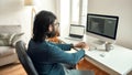 Software Programming. Side view of young male web developer wearing eyeglasses writing code on desktop computer, working Royalty Free Stock Photo