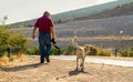 Sogut, Bilecik / Turkey - September 08 2019: Back rear view of an old photographer man and a street dog walking