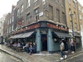 Soho district in London with a traditional pub and clients on a rainy day