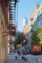 Soho street with person with dogs and One World Trade Center in New York