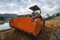 Soil compactor with vibratory padfoot drum. Heavy duty machinery working on highway construction site. Vehicle for soil