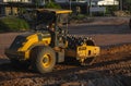 Soil compactor with vibratory padfoot drum. Heavy duty machinery working on highway construction site. Vehicle for soil