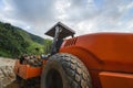 Soil compactor with vibratory padfoot drum. Heavy duty machinery working on highway construction site. Vehicle for soil