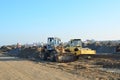 Soil Compactor and wheel loader at construction site. Vibration single-cylinder road roller leveling the ground for the construct
