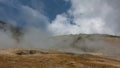 The soil in the geothermal valley is covered with orange sulfur deposits