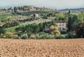 Soil for grapes of local farm in landscape of Tuscany with garden trees, mansions, green hills. Italian countryside