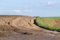 Soil road on the agrarian field, blurred with showers