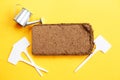 soil texture close up. coconut briquette with writing boards and watering can on a orange background