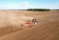 Soil Tillage in farmers country. Red Tractor on cultivating field work. Agricultural tractor on cultivation field for sowing seeds