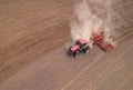 Soil Tillage in farmers country. Red Tractor on cultivating field work. Agricultural tractor on cultivation field for sowing seeds