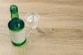 A soju bottle with glass of soju on the wooden table