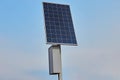 A solar battery on a pole against a blue sky energizes a street lamp