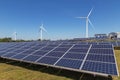 Solar cells with wind turbines generating electricity in hybrid power plant systems station on blue sky background Royalty Free Stock Photo