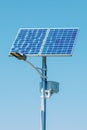 Solar device with street lamp on background of blue sky. Street light powered by solar panel with battery included. Alternative Royalty Free Stock Photo