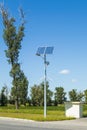 Solar device with street lamp on background of blue sky. Street light powered by solar panel with battery included. Alternative Royalty Free Stock Photo