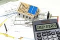 Solar energy cells on a blueprint or construction plan with calculator showing the word green energy
