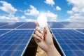 Solar energy panels and Light bulb in hand, energy Royalty Free Stock Photo