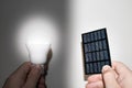 Solar panel and light bulb in hand Royalty Free Stock Photo