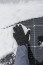 Solar energy in winter time.Getting electricity with solar panels in winter.Hands in gloves clear snow from solar panels Royalty Free Stock Photo