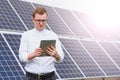 Solar energy. Young business man in a white shirt near the solar panels to power plants