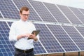 Solar energy. Young business man in a white shirt near the solar panels to power plants