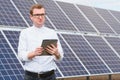 Solar energy. Young business man in a white shirt near the solar panels to power plants