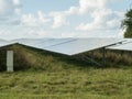 Solar Farm with grass and pale blue sky, East Sussex, UK