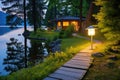 solar lamp illuminating a path to a picturesque lakeside retreat