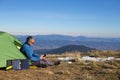 The solar panel attached to the tent. The man sitting next to mobile phone charges from the sun. Royalty Free Stock Photo