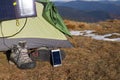 The solar panel attached to the tent. The man sitting next to mobile phone charges from the sun. Royalty Free Stock Photo