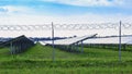 Solar panel on blue sky background. Green grass and cloudy sky.