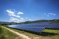 Solar panel on blue sky background. Panels installed in straight long rows. Green grass and cloudy sky Royalty Free Stock Photo