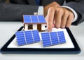 solar panel and house with solar panel on tablet with businessman hand