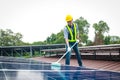 Solar panel installers use brushes to clean dust from solar panels to produce and sell electricity.