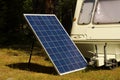 Solar panel with old caravan in a pine forest