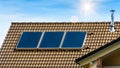 Solar panel on residential house rooftop. Solar system on roof of home close-up. Blue solar cells on building top for alternative