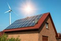 Solar panel on a roof of a house and wind turbins arround Royalty Free Stock Photo