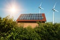 Solar panel on a roof of a house and wind turbins arround Royalty Free Stock Photo