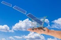 Solar panel in shopping trolley cart on women hand with photovoltaics falling from sky. Royalty Free Stock Photo