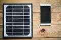 Solar panel and smartphone on the wooden table Royalty Free Stock Photo