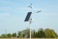 The solar panel stands on a pole with a street lamp against the blue sky. Royalty Free Stock Photo